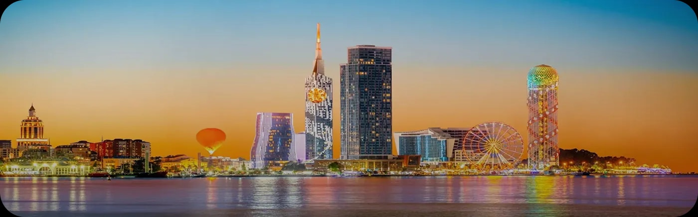 Tbilisi cityscape at dusk with the Bridge of Peace in the foreground
